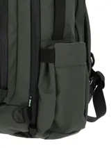 Mochila unisex de diseño técnico en color verde oscuro, fabricada en poliéster reciclado resistente al agua. Cuenta con múltiples compartimentos con cierres impermeables, bolsillo interno para laptop de 15 pulgadas, bolsillos laterales expandibles y correas ajustables ocultables. Incluye parche frontal con logo de la marca y llavero mosquetón decorativo.