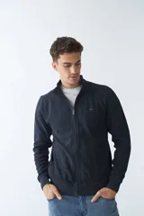 Campera negra de algodón con cierre completo, cuello alto, bolsillos laterales, puños y logo bordado en el pecho.