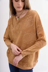 Sweater de moldería relajada, color camel, con escote redondo y manga larga. Tejido jacquard con diseño floral en lurex a tono que simula transparencias.