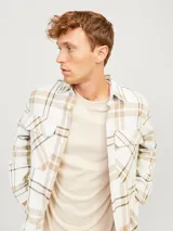 Sobrecamisa a cuadros color crema, marrón y blanco, de manga larga con cierre de botones y bolsillos en el pecho.