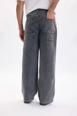 Pantalón de jean estilo skater color gris claro, de corte amplio y relajado, con bolsillos laterales grandes.