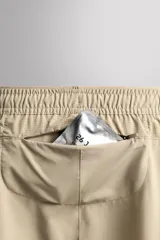Short deportivo Zara Athleticz de color marrón, confeccionado en tejido técnico ligero y elástico con forro interior. Cuenta con cintura elástica ajustable con cordón, bolsillos frontales, bolsillo trasero con cierre de cremallera, bajo con aberturas laterales y detalle de logo estampado en la pierna.