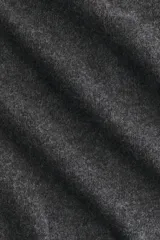 Top entallado en punto fino color gris melange, con cuello alto, mangas largas acampanadas y pinzas con efecto moldeador en la cintura. Cuenta con abertura de cerradura con botón en la parte posterior.