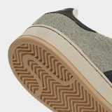 Championes Adidas modelo Campus 00s, con diseño inspirado en los años 80. Presentan una parte superior de gamuza texturizada en color verde oliva, con las icónicas tres rayas laterales en negro y detalle en el talón. Cuentan con cordones anchos y suela de goma en tono beige.