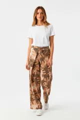 Pantalon de tiro alto confeccionado en viscosa, con diseño de pierna ancha y estampado animal print de leopardos. Presenta una solapa frontal superpuesta y cintura elástica con cordón ajustable.