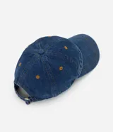 Gorra de sarga de algodón con acabado efecto denim azul, visera curva y paneles estructurados. Cuenta con ojales de ventilación superiores y cierre trasero ajustable.