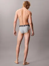 Pack de tres slips Calvin Klein de talle medio con cinturilla elástica distintiva de la marca. Incluye uno de color gris, uno negro y uno celeste.
