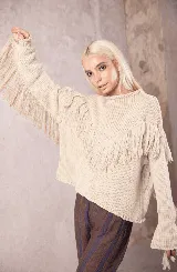 Sweater de tejido de punto color crudo, con cuello redondo y diseño holgado. Presenta detalles de flecos largos en el frente y a lo largo de las mangas, con puños acampanados.