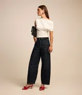 Blusa blanca de crepé con escote asimétrico y manga única corta con fruncido.