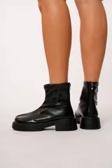 Botas cortas negras de cuero sintético con cierre en la parte trasera y suela track.