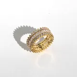 Anillo dorado con tres hileras de cristales blancos de diferentes tamaños.