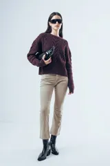 Sweater de punto color bordó con diseño de trenzas y relieves. Presenta cuello redondo, mangas largas y terminaciones acanaladas en puños y ruedo.