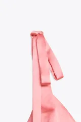 Top de satén rosado con escote en pico y tirantes finos que se atan con lazos.