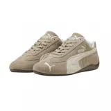 Championes Puma modelo Speedcat Elevated, confeccionados en gamuza color beige con detalles en tono más claro. Presentan el logo de la marca en el lateral y en la puntera, con suela de goma marrón de perfil bajo inspirada en el automovilismo.