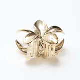 Pinza para el pelo con diseño de flor en metal dorado, con mecanismo de agarre tipo clip.