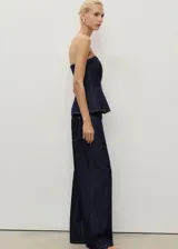 Top estilo corsé de mezclilla azul oscuro, sin mangas, con escote palabra de honor y corte peplum.
