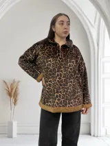 Buzo marrón con estampado animal print y cuello polo con cierre de cremallera.