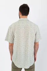 Camisa de manga corta con estampado de líneas verdes sobre fondo blanco, confeccionada en tela crepé.