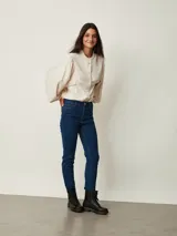 Jean chupín negro de tiro alto, confeccionado en denim con cinco bolsillos tradicionales y cierre frontal con botón y cremallera.