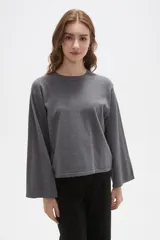 Remera de manga larga confeccionada en viscosa, con cuello redondo a la base y diseño holgado.