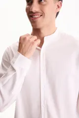 Camisa de manga larga color beige con cuello mao y cierre frontal con botones.
