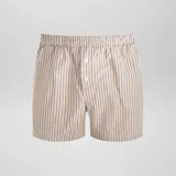 Pack de tres bóxer de algodón con cintura elástica y botón frontal. Uno con rayas verticales azules y amarillas, otro con lunares marrones sobre fondo celeste y otro con rayas verticales marrones y beige.