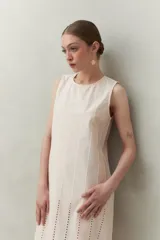 Vestido largo blanco de algodón con calados verticales y bordado tipo ojo de perdiz, sin mangas y de silueta recta.