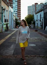 Sweater de hilo de algodón color tostado, con diseño tejido de la bandera de Uruguay en el frente, de manga larga y calce holgado.