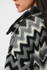 Tapado largo de lana con estampado zigzag horizontal en tonos grises y negros, de manga larga y abotonado.