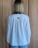 Camisa de jean azul con cuello alto con volados y volados en el frente.