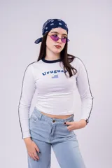 Remera de manga larga color blanco con cuello redondo y franjas laterales en color azul marino. Presenta la palabra Uruguay estampada en el pecho junto a una pequeña bandera nacional.
