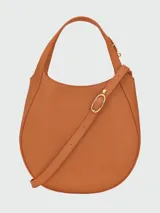 Cartera de mano Longchamp modelo Le Foulonné S, de diseño redondeado y estructura rígida, confeccionada en cuero con acabado liso y asa superior integrada.