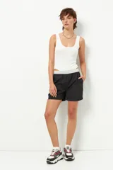 Short deportivo negro con detalles en verde militar, cintura elastizada, bolsillos laterales y ribete blanco.
