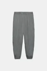 Pantalón de tiro medio con cintura elástica, bolsillos laterales ocultos y bajo con puño elástico. Presenta un diseño de tejido con efecto arrugado.
