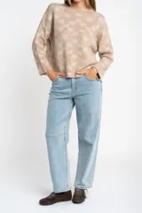 Sweater de punto con diseño de cuadros en tonos marrón y beige, de cuello redondo y manga larga.