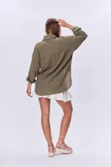 Camisa verde militar de manga larga con dos bolsillos frontales con solapa y cierre con botones.