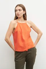 Top halter color naranja de lino con breteles finos y corte holgado.