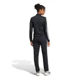 Conjunto deportivo Adidas Essentials 3 Tracksuit para mujer, color negro con tiras blancas en las mangas y los laterales del pantalón. Incluye campera con cierre frontal y cuello mao, y pantalón con elástico en la cintura.
