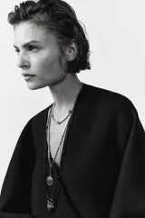 Gargantilla de metal dorado compuesta por una cadena de eslabones tubulares alternados con esferas lisas, con cierre de mosquetón ajustable.