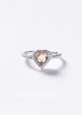 Anillo de plata 925 con diseño de corazón central compuesto por una zirconia amarilla en forma de corazón rodeada por un halo de pequeñas zirconias blancas, con banda delgada también decorada con zirconias.