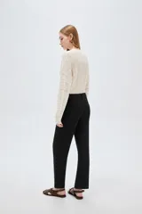Pantalón jean negro de tiro medio y corte flare, con bolsillos laterales y traseros.