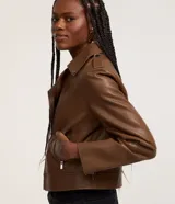 Campera biker marrón de cuero sintético con cierre asimétrico, cuello con solapas y bolsillos con cremallera.