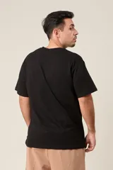 Remera negra de algodón con estampado frontal de la palabra "Emotion" en color blanco.