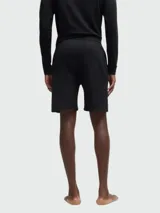 Shorts deportivos negros de felpa con cintura elástica ajustable con cordón, bolsillos laterales y logo metálico dorado de la marca Boss en la pierna izquierda.