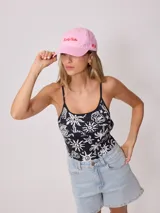 Gorra de lona color crema con visera celeste. Presenta bordado frontal en hilo azul claro con el texto "Rusty Tribe" y un pequeño diseño de flores.