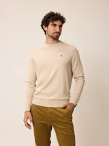 Sweater de punto con cuello redondo, manga larga y puños acanalados. Presenta un pequeño bordado en el pecho.