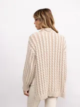 Sweater de punto con diseño de trenzas verticales, cuello alto y silueta oversize. Presenta un patrón bicolor en tonos azul y azul oscuro, con mangas largas y terminaciones en tejido acanalado.