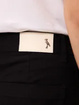 Short negro de gabardina con pinzas delanteras, bolsillos laterales y cierre frontal con botón metálico.