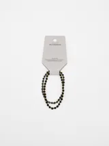 Pack de dos pulseras elásticas compuestas por pequeñas cuentas facetadas en tonos negros y dorados.