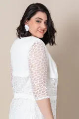 Vestido blanco de piqué con encaje en el escote, corte recto y largo a la rodilla. Incluye una túnica larga de la misma tela con tajos laterales y encaje al tono.